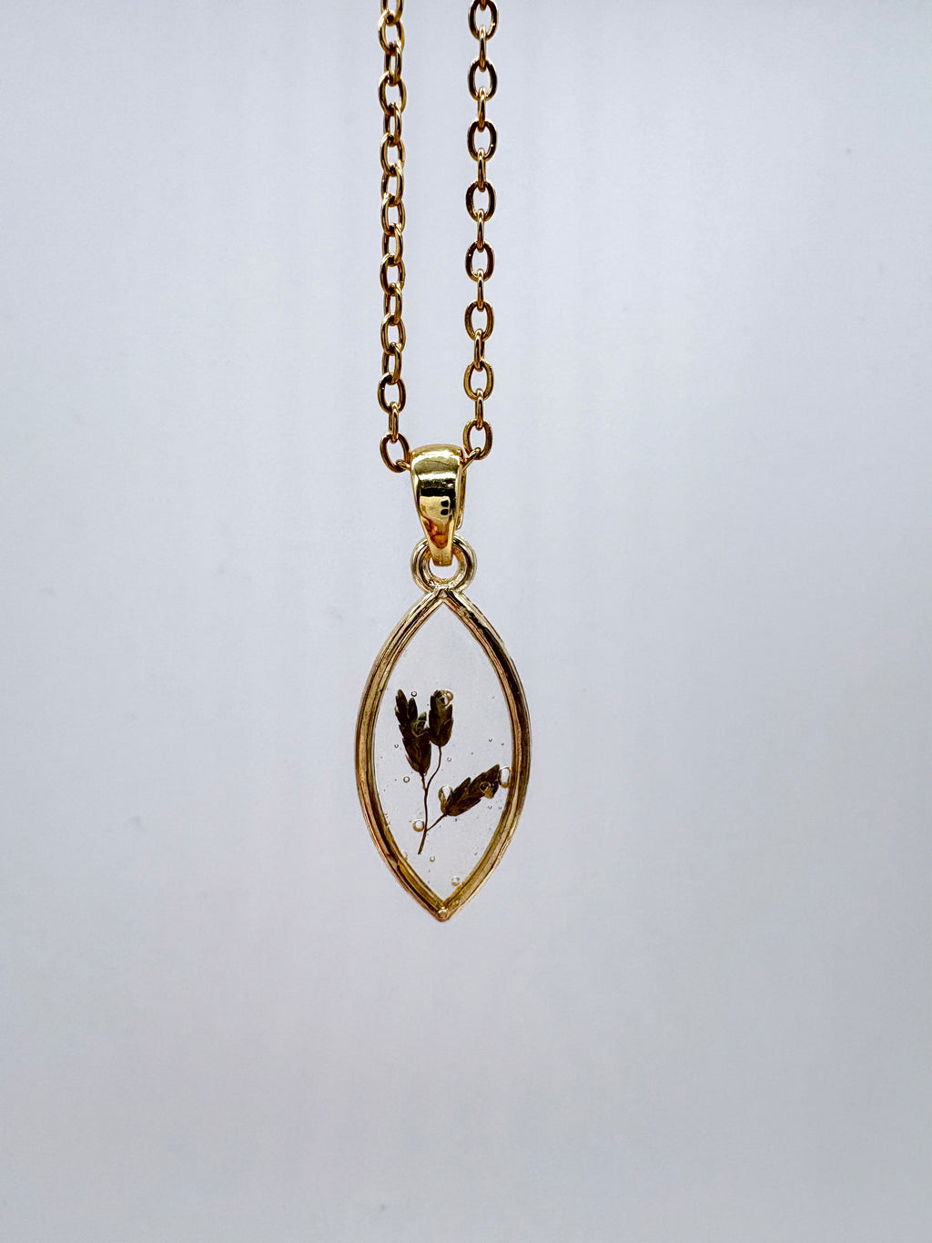 Goldkette mit Barreliers Liebesgras in Augenform, Detail, filigranes Design mit Blumenanhänger 

