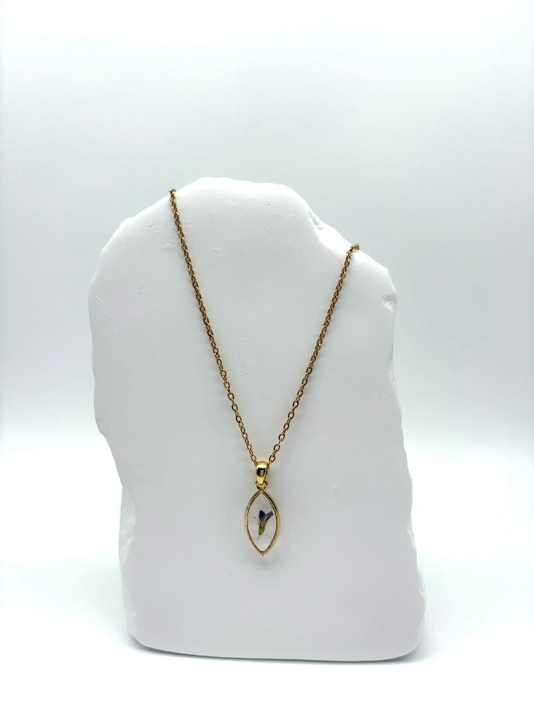 Goldkette mit Echte Luzerne2 in Augenform, getragen, filigranes Design mit Blumenanhänger 
