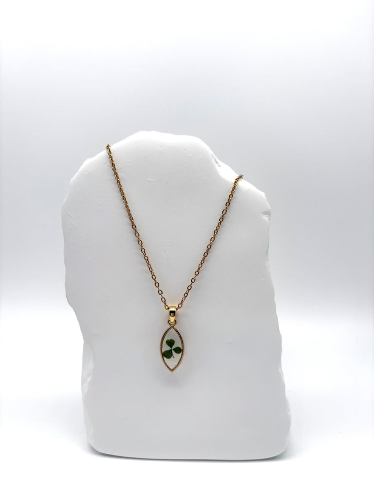 Goldkette mit Kleiner Klee in Augenform, getragen, filigranes Design mit Blumenanhänger 

