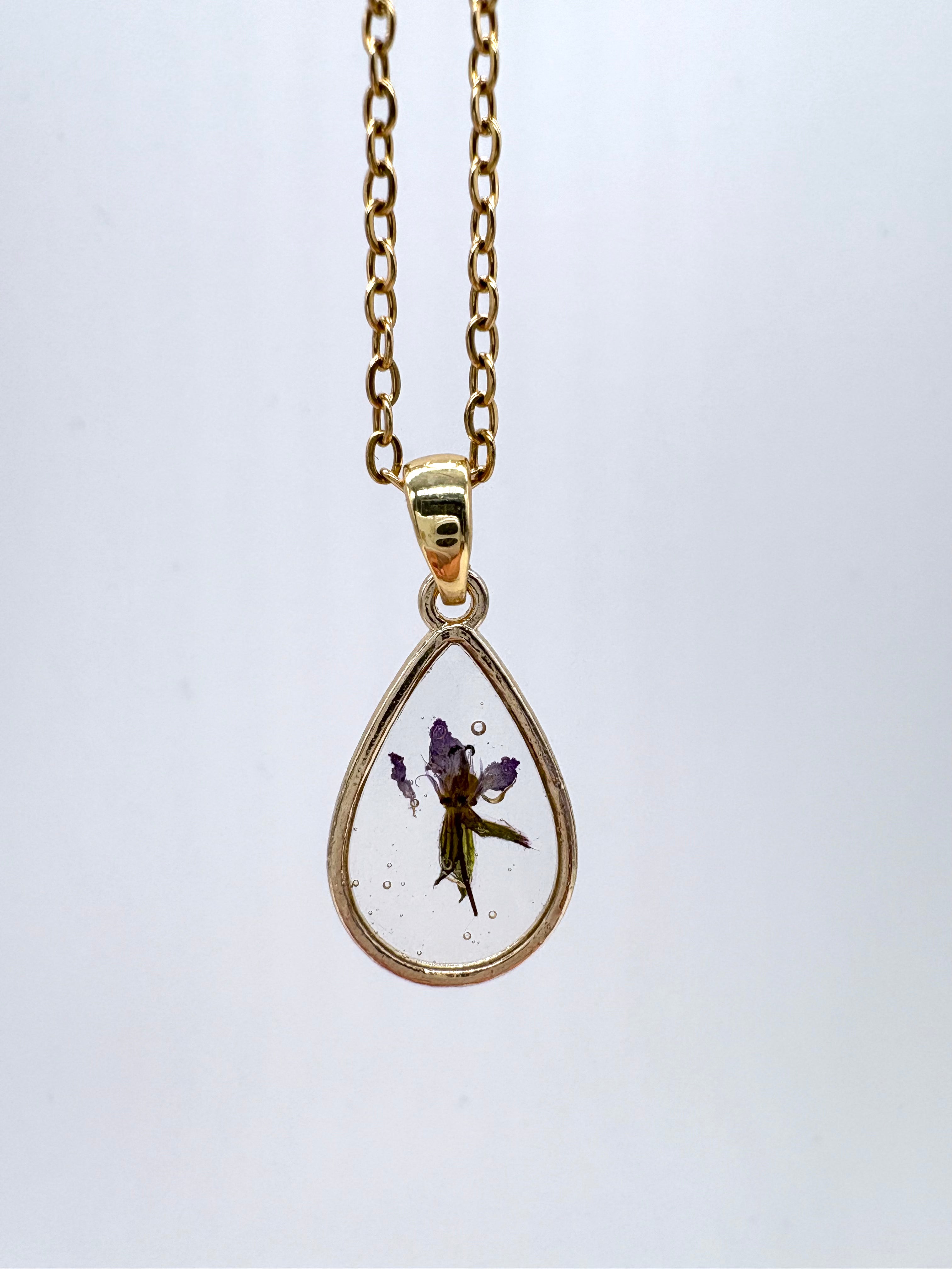 Goldkette mit Langschnäbeliger Reiher-Schnabel in Augenform, Detail, filigranes Design mit Blumenanhänger 
