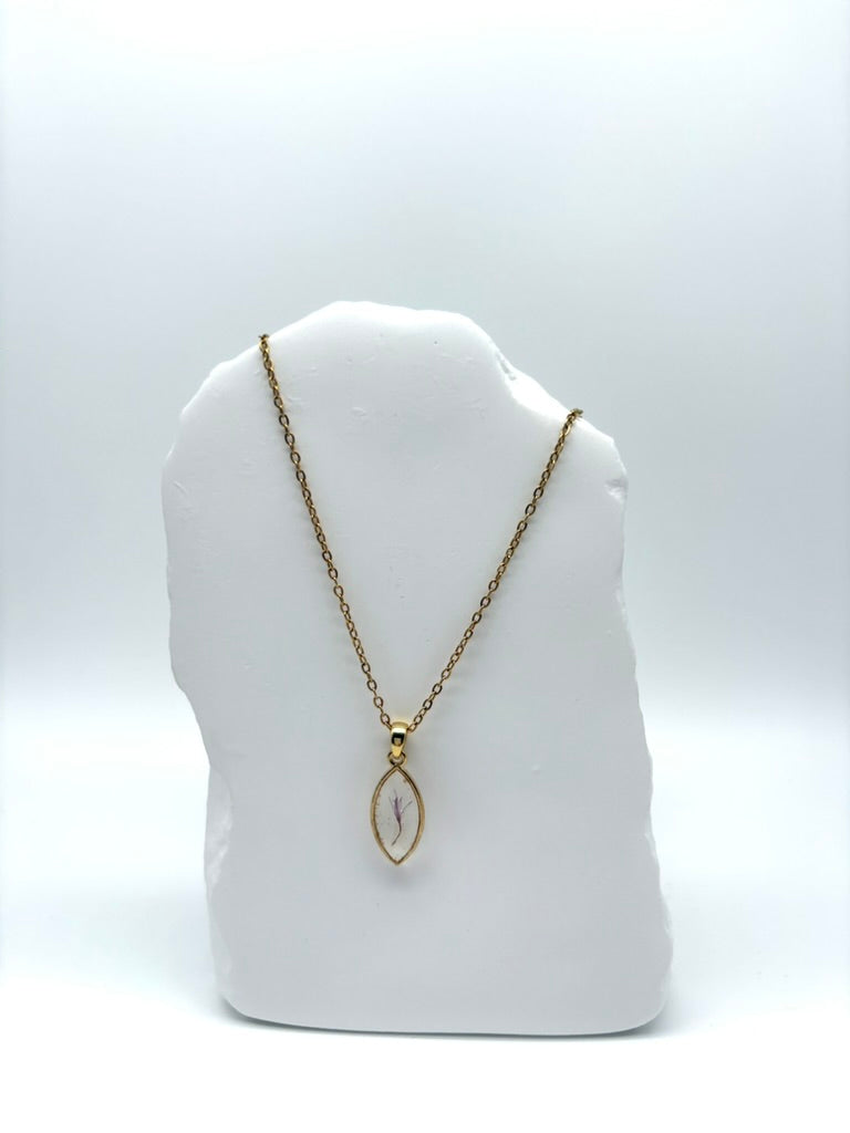 Goldkette mit Milchdistel in Augenform, getragen, filigranes Design mit Blumenanhänger 
