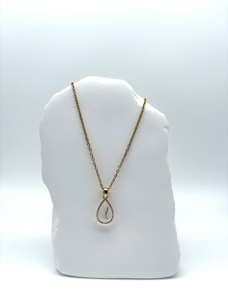 Goldkette mit Milchdistel in Augenform, getragen, filigranes Design mit Blumenanhänger 
