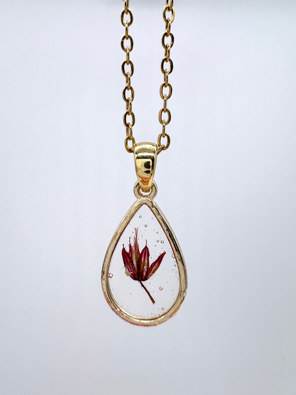 Goldkette mit Purpurstorchschnabel in Augenform, Detail, filigranes Design mit Blumenanhänger 
