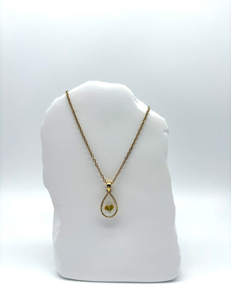 Goldkette mit Raue Goldrute in Augenform, getragen, filigranes Design mit Blumenanhänger 
