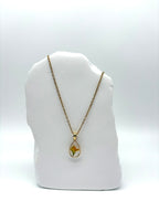 Goldkette mit Wiesen-Platterbse in Augenform, getragen, filigranes Design mit Blumenanhänger 
